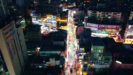 aerial drone view of cyberpunk city over a shopping street in korea at night