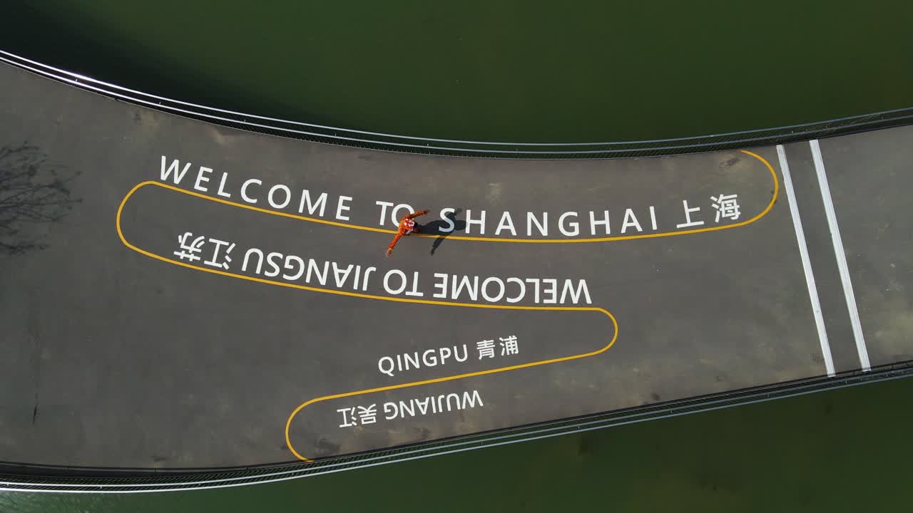 turista caminando por el camino de 'bienvenido a shanghai' en china, vista aérea de arriba hacia abajo