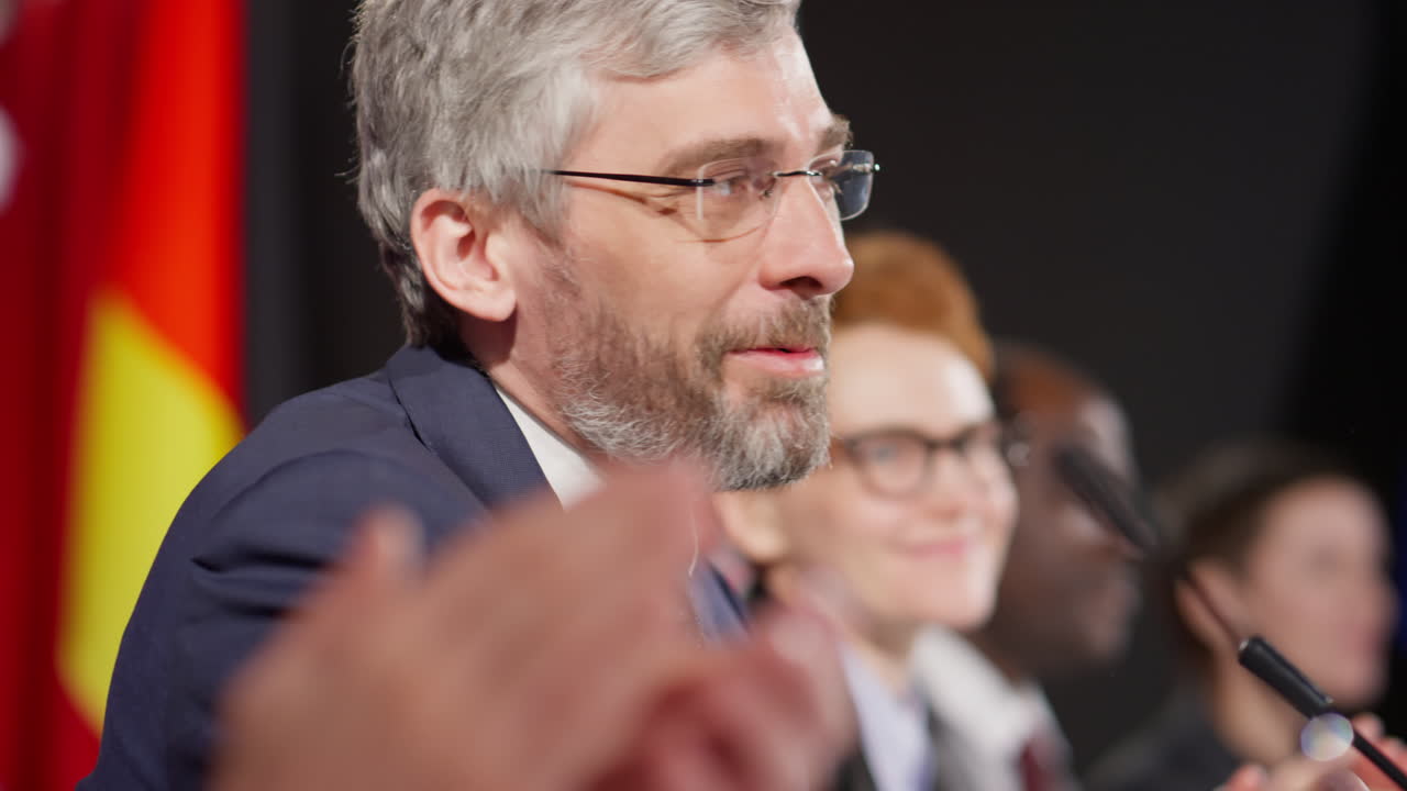 Leader politico allegro che applaude alla conferenza stampa