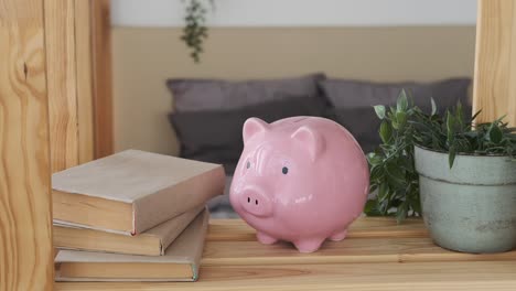 boy inserting coin into piggy bank