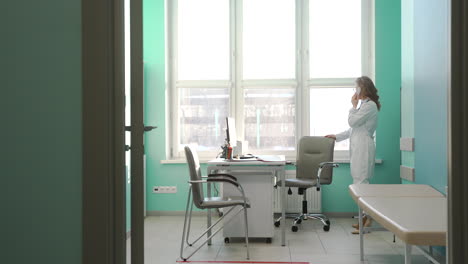 female doctor talking on phone with patient and looking at agenda for appointment