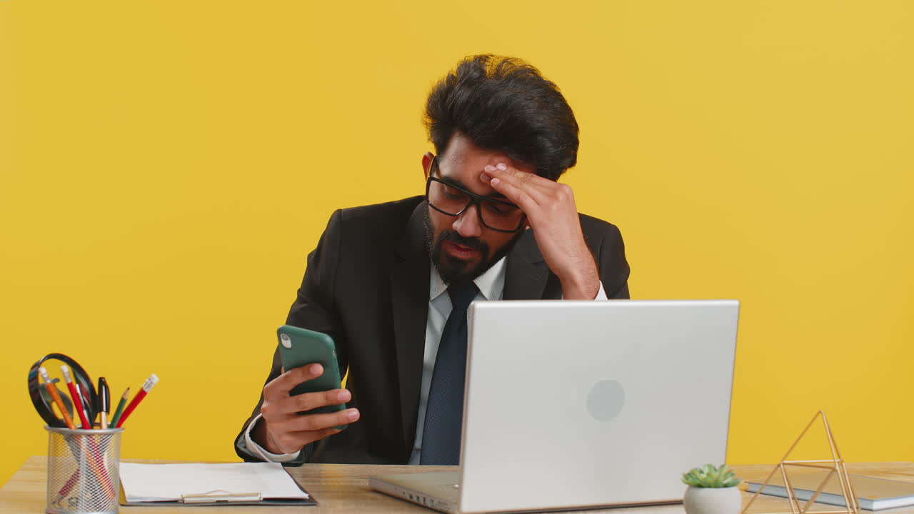 Indian office business man use smartphone surprised by bad news fortune loss fail lottery results