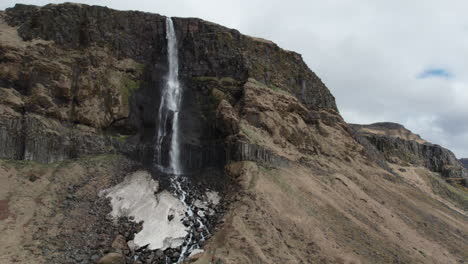 bjarnarfoss waterfall: aerial motion shot in orbit of the fantastic icelandic waterfall on a sunny day