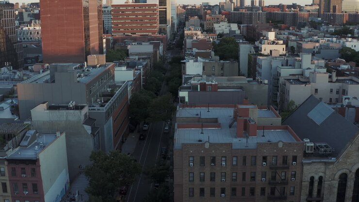 Lento volo aereo e inclinazione verso l'alto che guarda giù la 126a Strada ad Harlem, New York City, subito dopo l'alba.