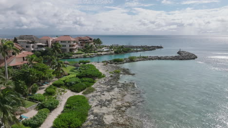 A-beautiful-aerial-view-of-a-beachfront-house,-perched-above-the-Caribbean-Sea