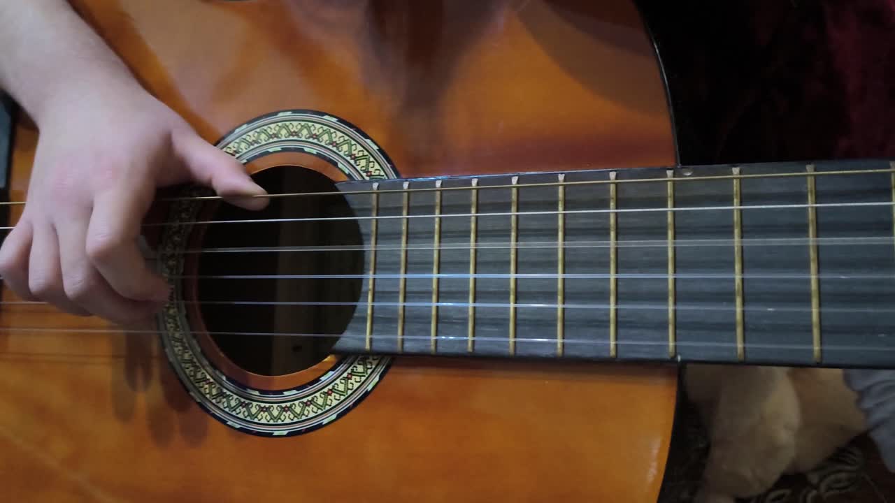 Niño tocando la guitarra, primer plano de la mano