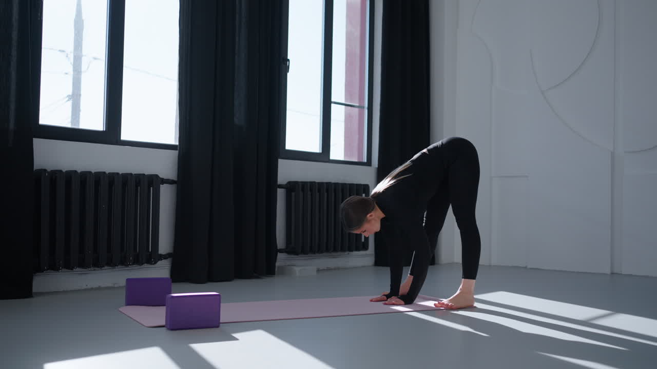mujer haciendo una postura de yoga en un estudio