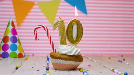 feliz cumpleaños para un niño de diez años, un hermoso fondo de video feliz cumpleaños por un niño de 10 años en un fondo rosa con un pastel de crema y una vela con fuego.