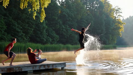 friends jumping in a lake at sunrise