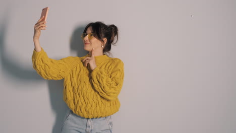 woman taking a selfie in a yellow sweater