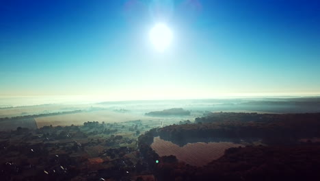 morning sunrise in the village on misty weather. panoramic view of beautiful dawn over the roofs of the houses and big forest. aerial view. soft sun light. slow motion.