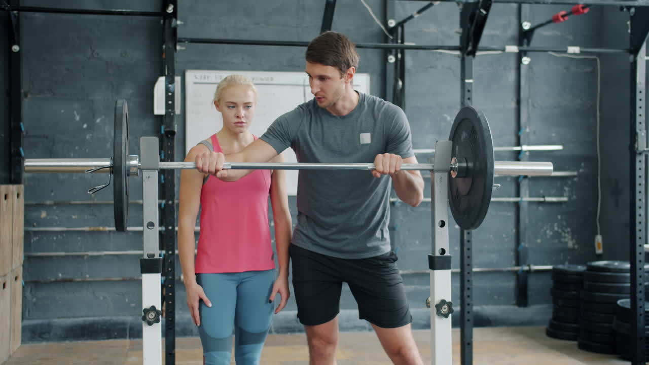 Woman Training With Personal Trainer In Gym