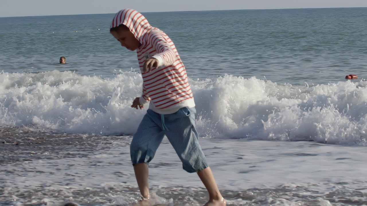 niño jugando en las olas en la playa