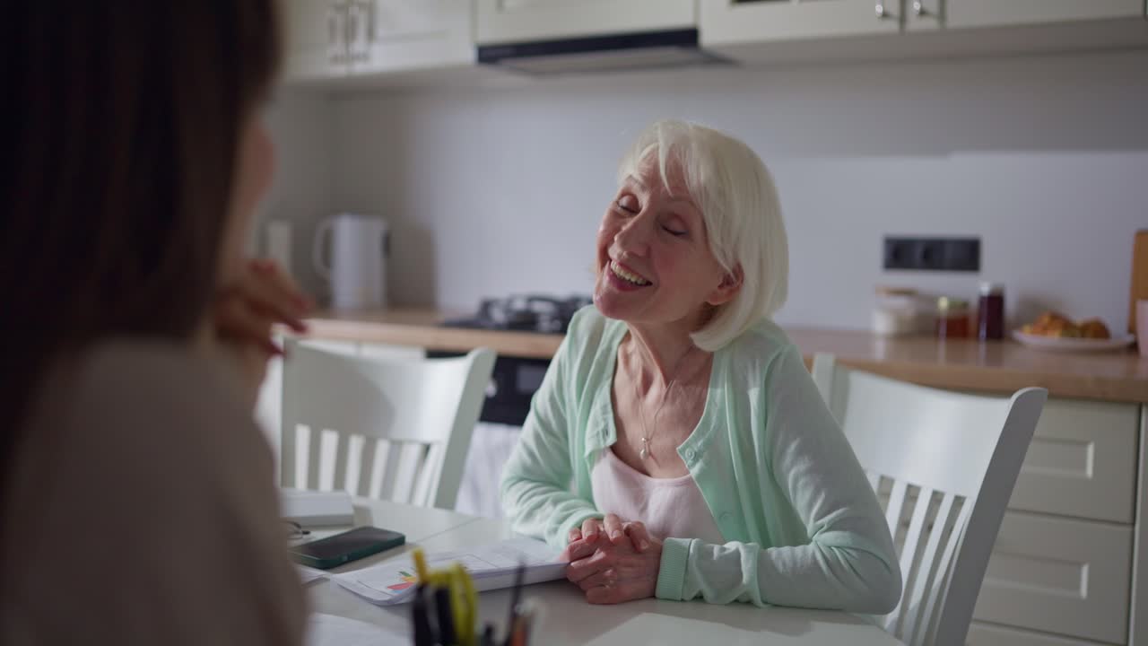 Elderly Woman Having a Conversation in the Kitchen
