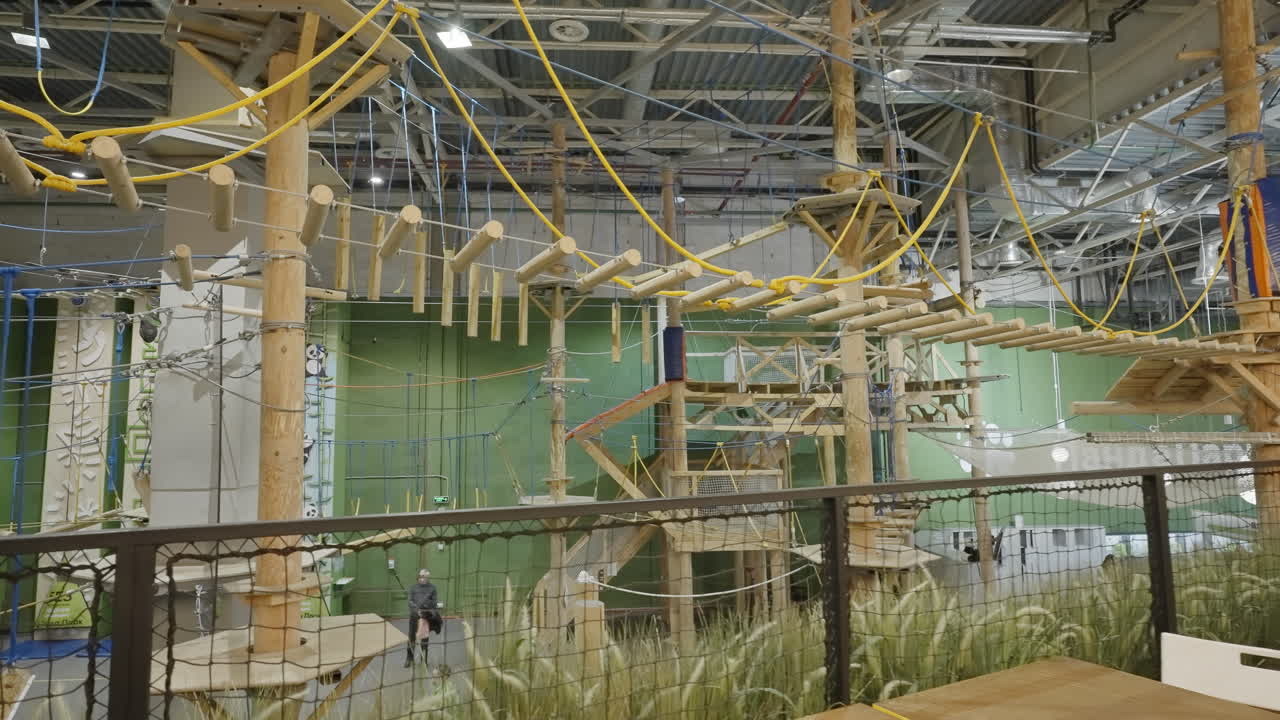 gimnasio de escalada cubierto con estructuras de madera y pista de obstáculos