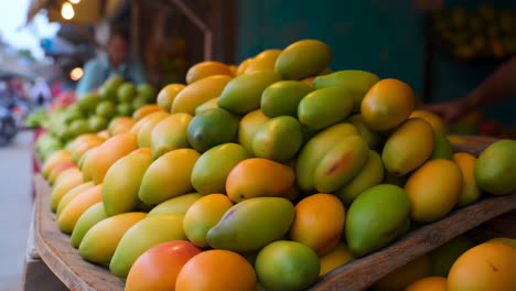 fresh mangoes on display at an outdoor market stall