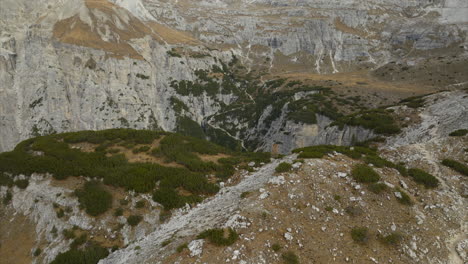 Vuelo-Aéreo-Sobre-La-Cima-De-Una-Montaña-Rocosa-Para-Revelar-El-Majestuoso-Suelo-Del-Valle-En-Tre-Cime-Di-Lavaredo