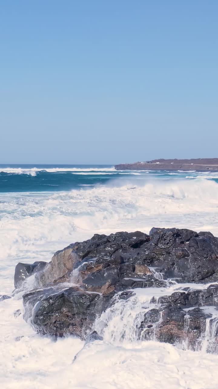 Onde oceaniche impetuose che si infrangono sulla costa rocciosa