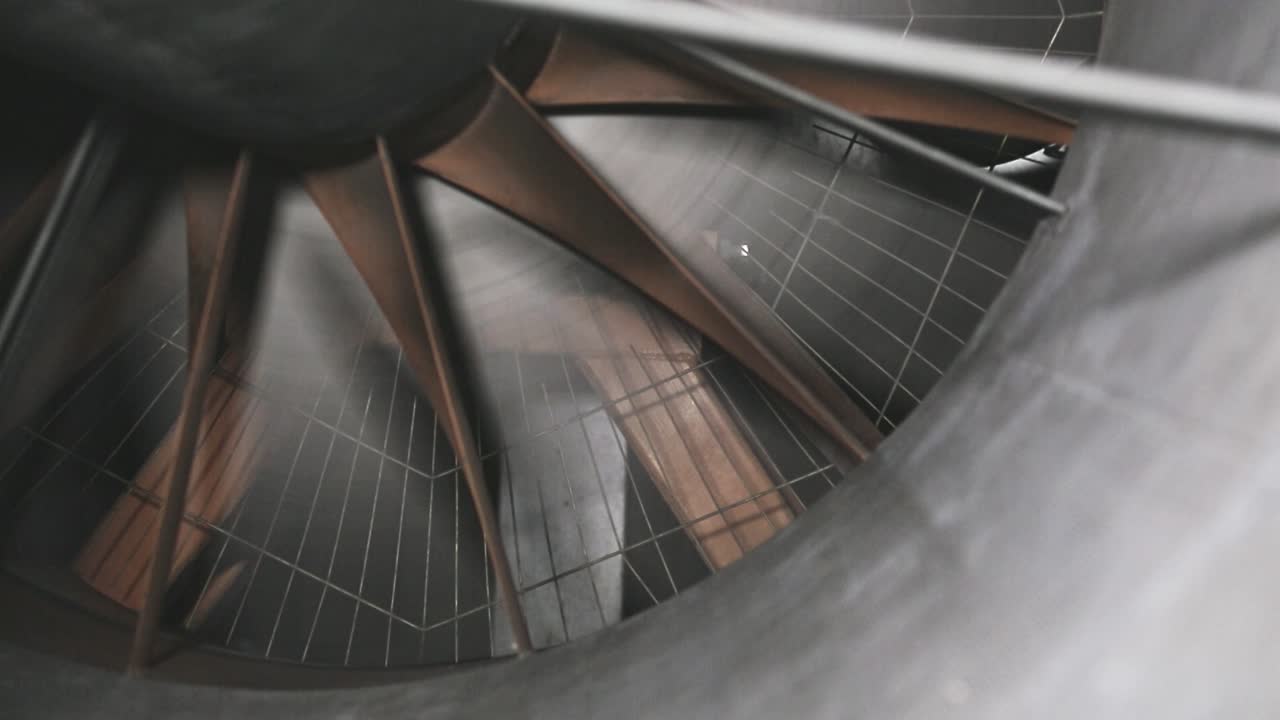 Large industrial wind tunnel fan starting and stopping at a renewable energy test site. The rotating blades and mechanical details illustrate aerodynamics, airflow research, and energy technology