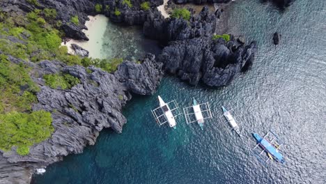 island hopping tourists swimming from tour boats to the secret beach in el nido, philippines