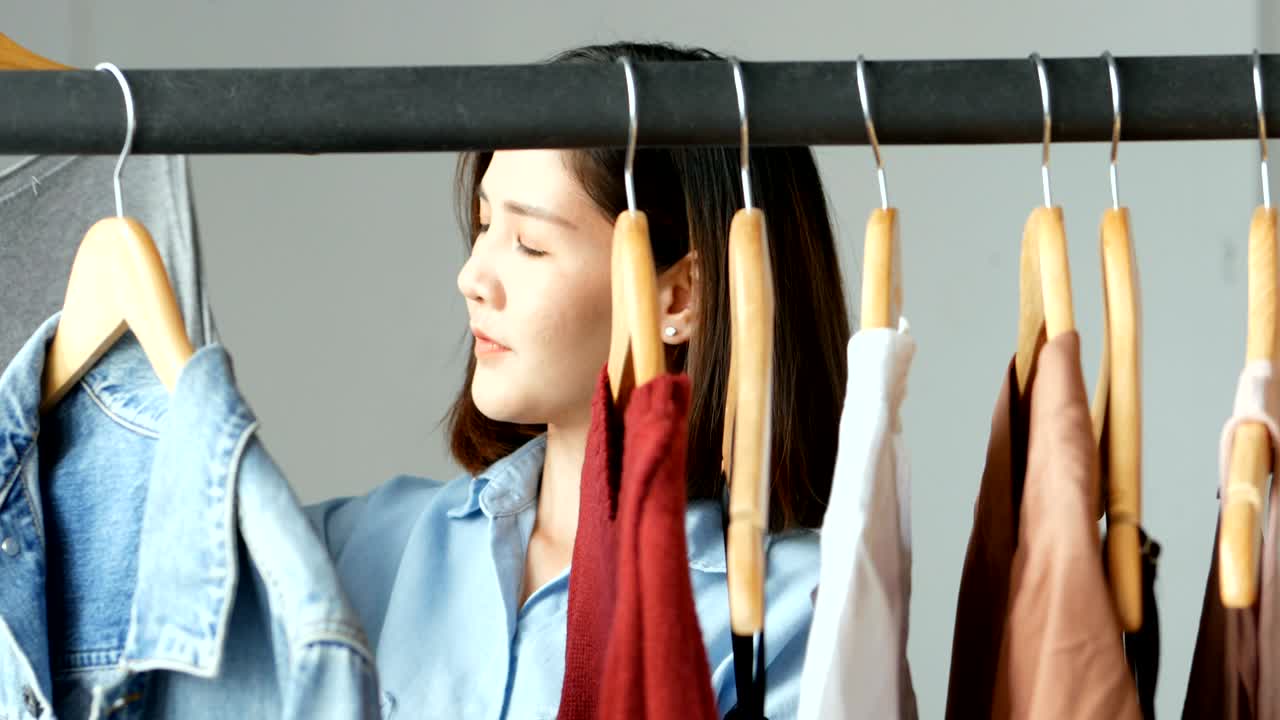 젊은 아시아 여성이 패션 가게를 둘러보고 있습니다. 근접 촬영.