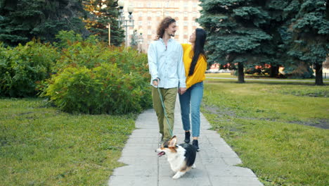 couple walking dog in park