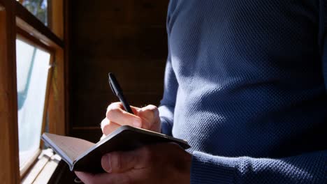 Man writing on a diary at home 4k