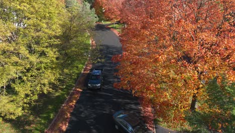 cars driving in new england neighborhood during autumn