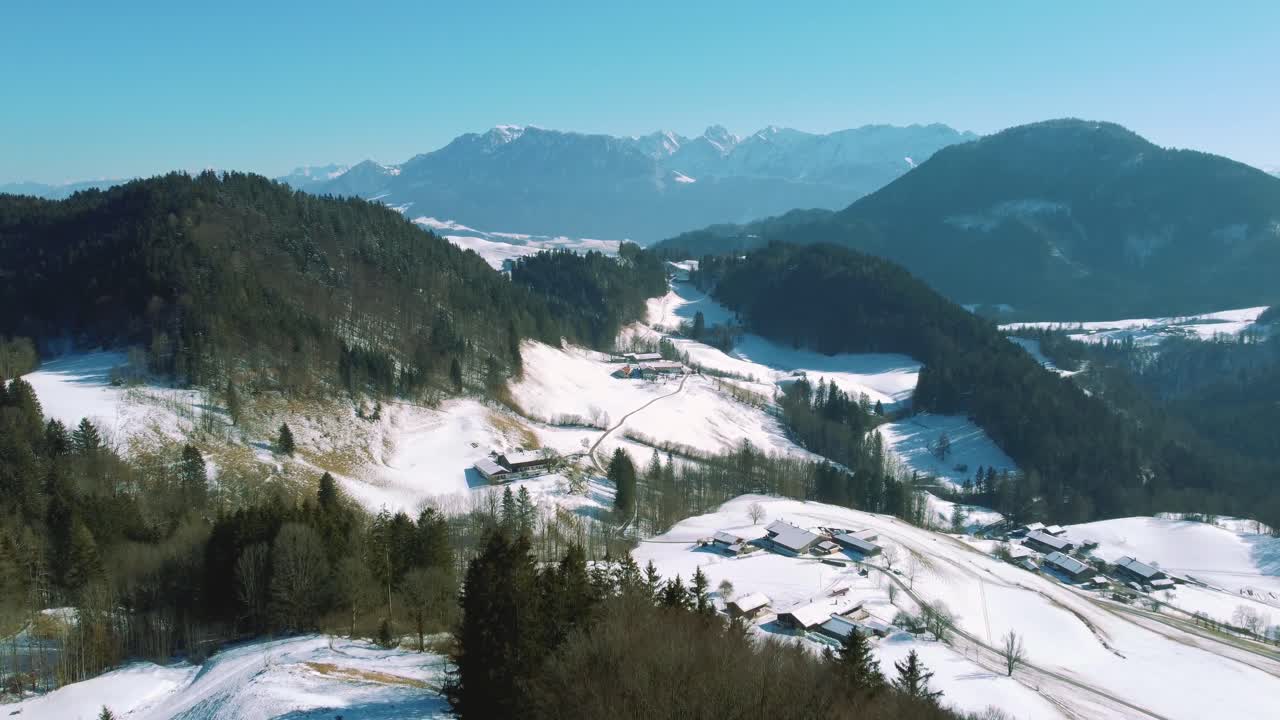 vuelo aéreo de drones de 4k que se mueve sobre colinas nevadas y copas de árboles en los alpes bávaros en invierno en alemania, cerca de austria