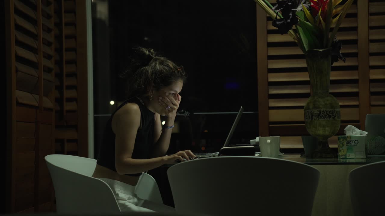 Tired Remote worker digital nomad female working late at night from home