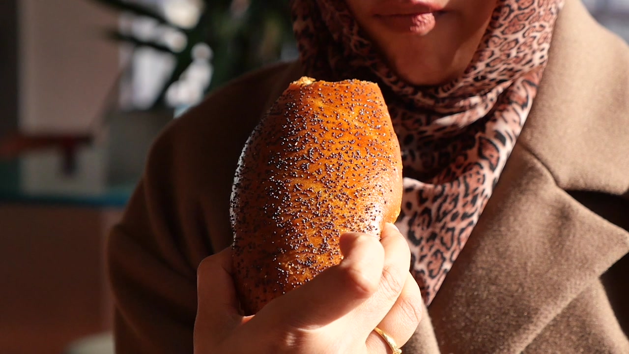 Close-up of a Person Holding a Poppy Seed Pastry