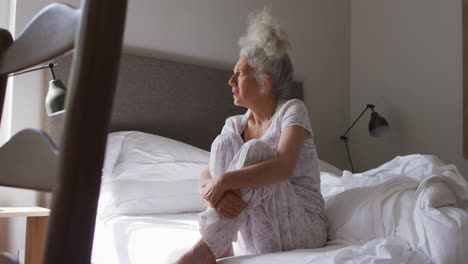 Senior-caucasian-woman-sitting-on-the-bed-at-home