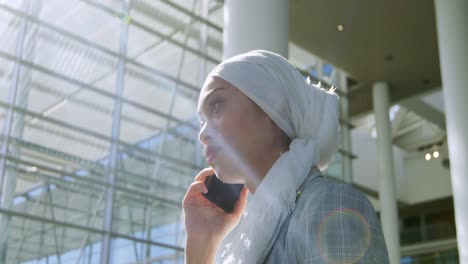 Mujer-De-Negocios-Usando-Un-Teléfono-Inteligente-En-Un-Moderno-Edificio-De-Oficinas