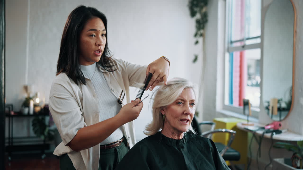 Hairstylist Cutting and Styling Senior Woman's Hair in a Modern Salon