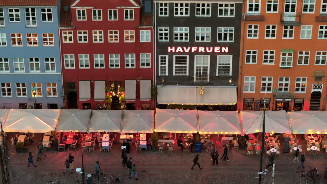 Aerial drone view of the Nyhavn waterfront, canal and entertainment district in Copenhagen, Denmark in the evening
