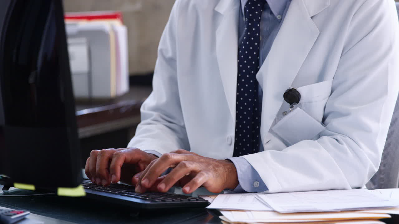 Mixed race male doctor using computer in his office