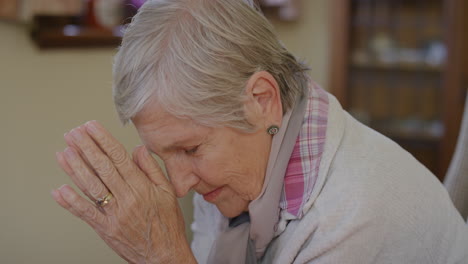 portrait of old caucasian woman praying looking up hopeful retired senior female in retirement home