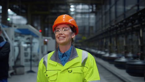 joyful engineer laughing safety uniform at modern warehouse say hello closeup.