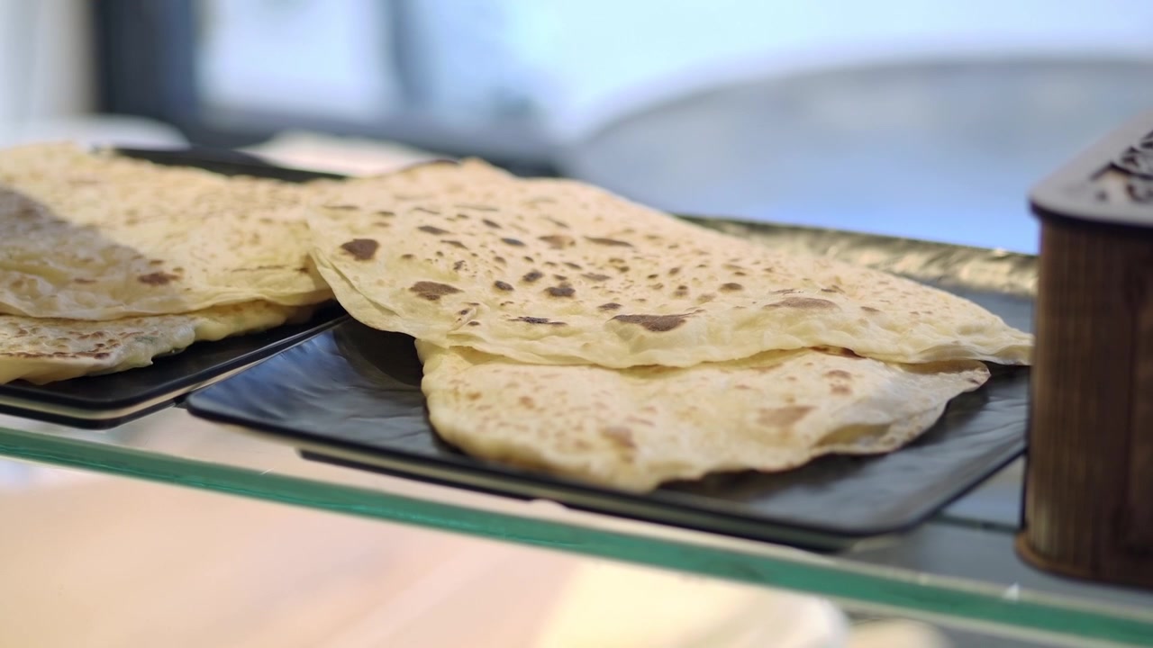 Freshly Baked Flatbread Being Placed on a Display Tray