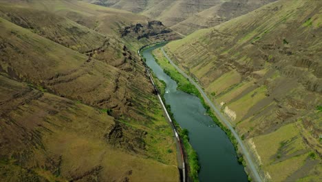 US, Oregon, Maupin, Deschutes River, 2025-05-08 - Drone view of a cargo train moving down the Deschutes River in north central Oregon in spring