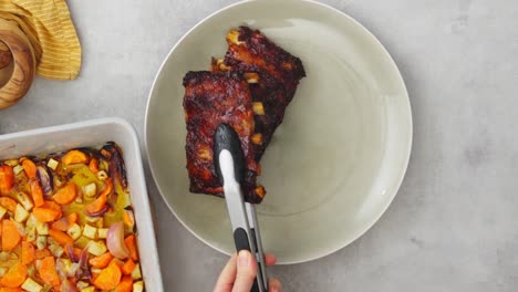 Persona-De-Cultivo-Poniendo-Costillas-Fritas-En-El-Plato.