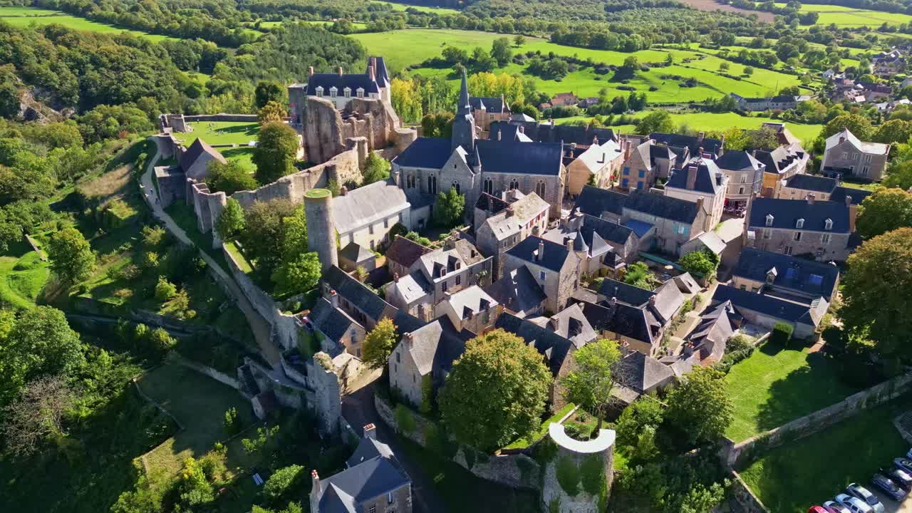 Drone pullback panoramic establishing of historic hilltop village and medieval castle in the French countryside