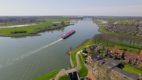 Vista-Aérea-Del-Barco-Rojo-Navegando-Río-Abajo-En-El-Campo-Holandés