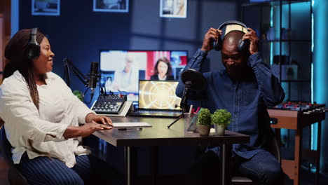 woman on podcast adjusting analog mixer while talking with guest during marathon streaming