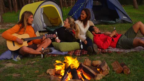 friends having fun near campfire in the forest 4k