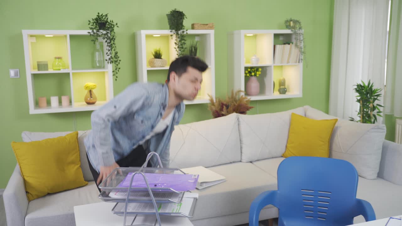 홈 오피스에서 일하는 어색한 남자가 테이블에 다리를 때립니다.