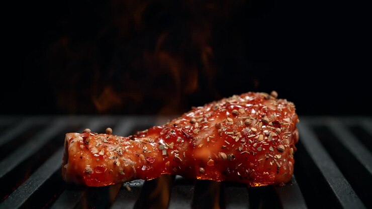 Marinated Seasoned Drumstick Falling Onto The Grill Flaming In Slow Motion on the Black Background