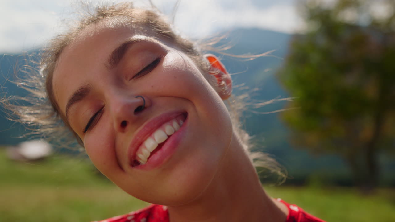 Primer plano del rostro de mujer feliz con sonrisa radiante. Retrato de chica disfrutando del sol