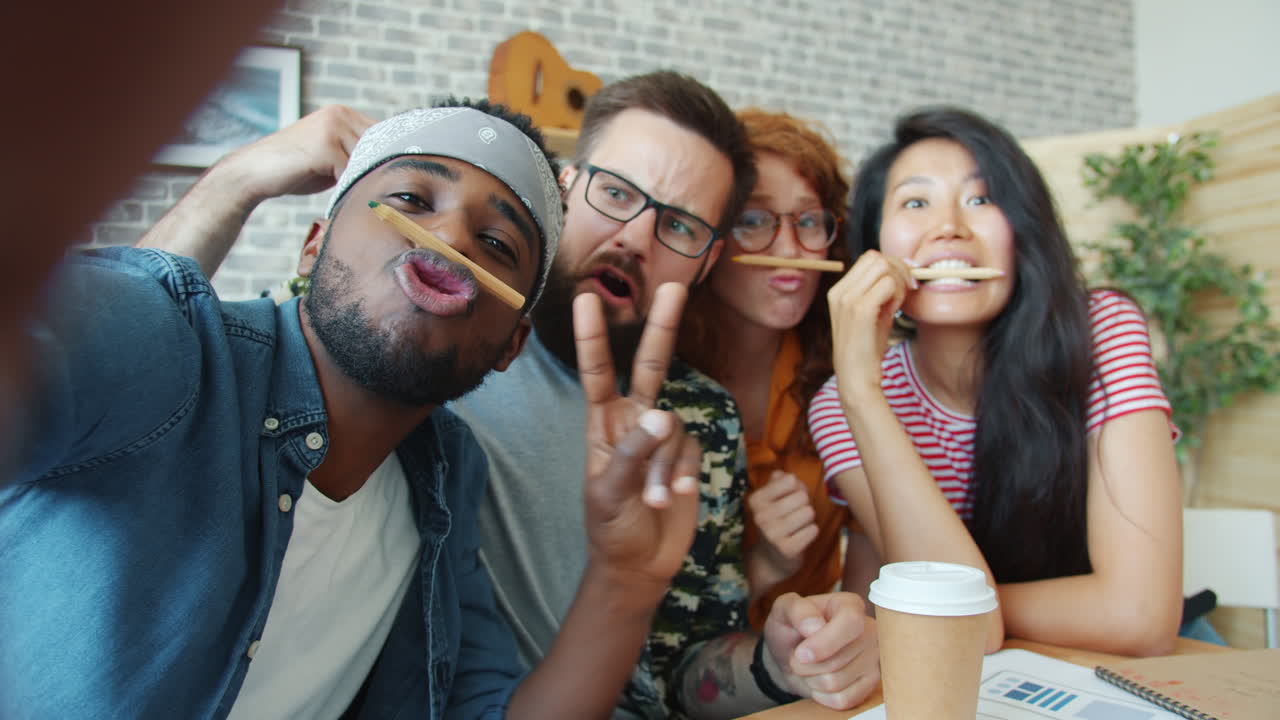Friends Taking a Selfie with Pencils on their Faces