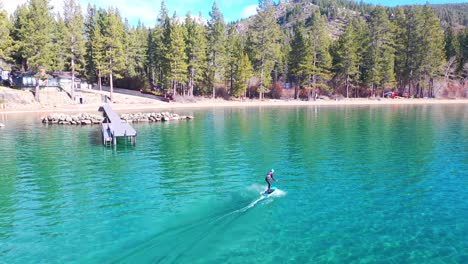 2020 - a man rides a hydrofoil efoil electronic surfboard across lake tahoe california in an extreme hydrofoiling foil sport demonstration 2